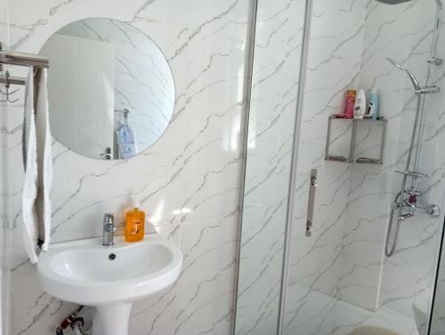bagno bianco con lavandino e specchio di Luxury Cosy Homestay with Private Entrance a Eldoret
