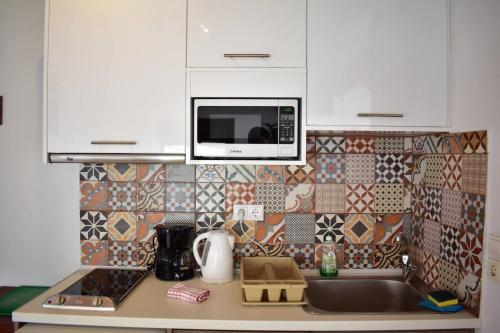 a kitchen with a sink and a microwave at Marinakis Sea View Studios in Sougia