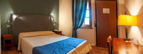 een slaapkamer met een bed, een tafel en een raam bij Hotel Ristorante La Fattoria in Spoleto