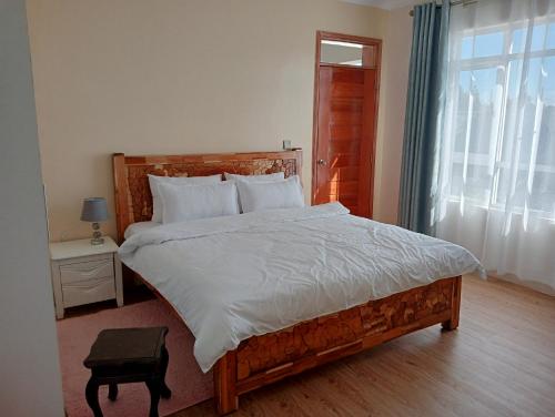 a bedroom with a large bed and a window at Luxury Cosy Homestay with Private Entrance in Eldoret