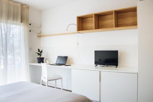 1 dormitorio con 1 cama y escritorio con ordenador portátil en Twenty Business Flats Le Mans Ouest en Le Mans