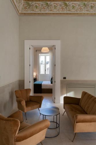 a living room with a couch and chairs and a bed at Palazzo Tafuri Boutique Hotel in Nardò