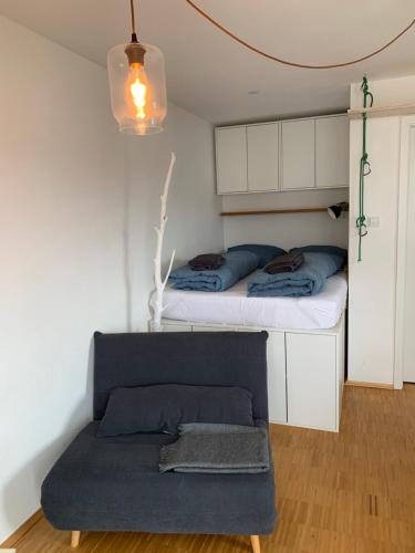 - une petite chambre avec un lit et un canapé dans l'établissement Topmodernes Studio - Sommer im bayerischen Inntal, à Brannenburg