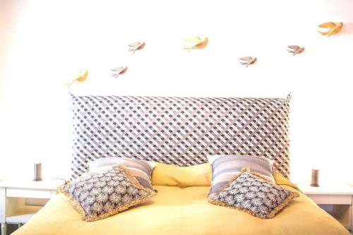 a yellow bed with two pillows on top of it at Les Champs du Levant in Cudrefin