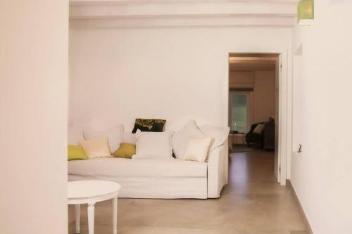 a living room with a white couch and a table at Les Champs du Levant in Cudrefin