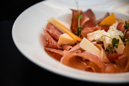 a plate of food with cheese and other foods at Casa Del Sole in Alba Iulia