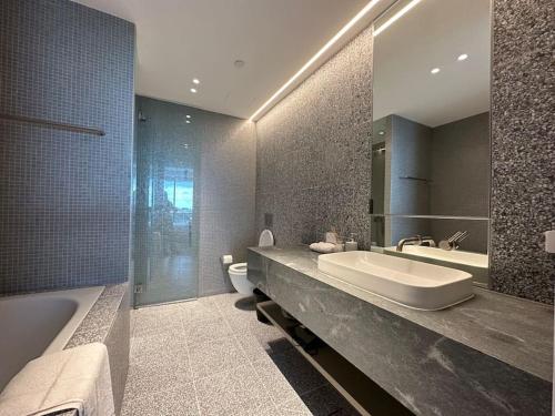 uma casa de banho com um lavatório, uma banheira e um WC. em City view designed apartment in Bondi Junction em Sydney