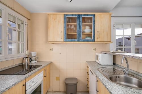a kitchen with wooden cabinets and a sink at La Duquesa apartment with pool Ref M8 in Manilva