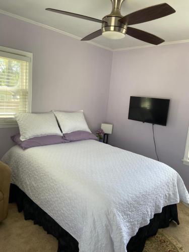 a bedroom with a white bed with a ceiling fan at Cozy comfortable PRIVATE BEDROOMS in Atlanta