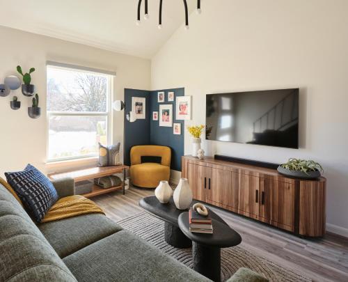 a living room with a couch and a flat screen tv at Midcentury Couples Designer Loft - Casa Tuya in Austin