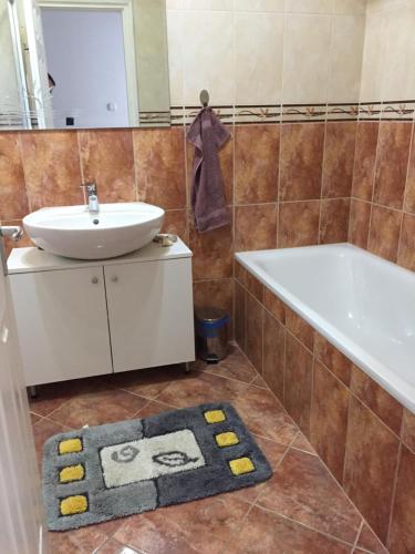 a bathroom with a tub and a sink and a bath tub at Solemio Apartman Kalocsa in Kalocsa