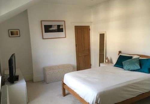 a bedroom with a large bed and a television at Westgate Two-Bedroom Homestay Suite in Westgate-on-Sea