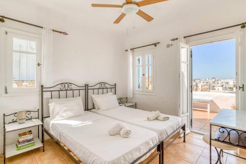 two beds in a bedroom with a balcony at Thálassa House - Walking distance to Naoussa in Naousa