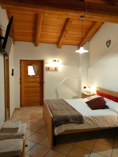 a bedroom with a bed and a wooden ceiling at La Majon de Fohten in Montjovet