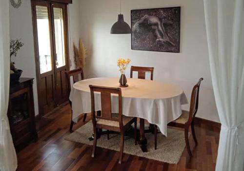 einen Esstisch mit einer Blumenvase darauf in der Unterkunft Apartamento Teresa in Pontevedra