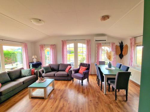 a living room with a couch and a table at De Parel van Zeeland met jacuzzi en sauna in Sint Annaland