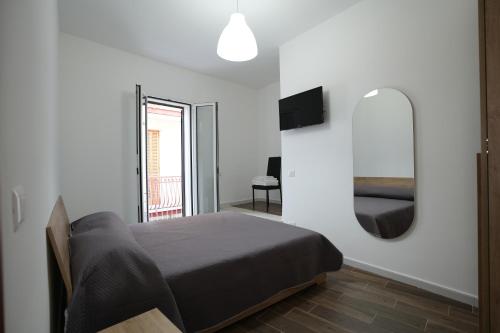 Un dormitorio con una cama y un espejo en la pared. en La stradina, en Mola di Bari