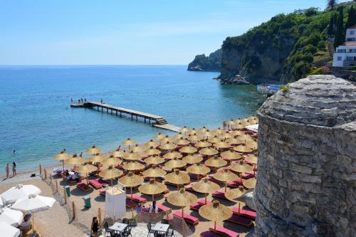 a group of umbrellas on a beach next to the ocean at Montenegro Backpackers Home Budva in Budva