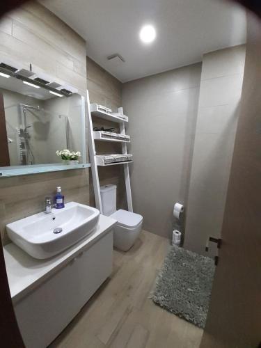 a bathroom with a sink and a toilet at m2 Tbilisi Central Park Apartment in Tbilisi City