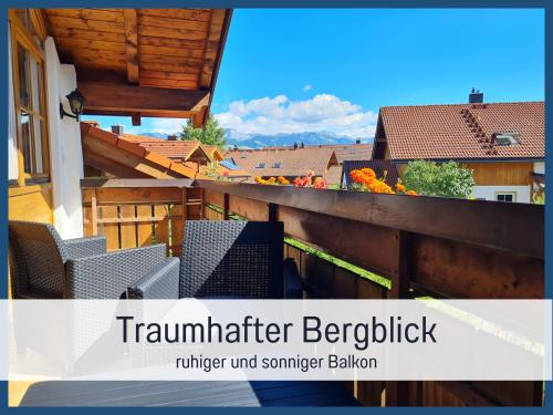 a balcony with chairs and a view of the city at Ferienwohnung am See mit Bergblick & Sonnenbalkon in Blaichach