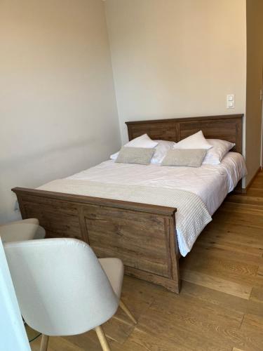 een bed met een houten frame en een stoel in een kamer bij Apartament Garbary 234 in Poznań