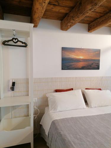 1 dormitorio con 1 cama y una foto en la pared en VERDEPOESIA, en Chioggia