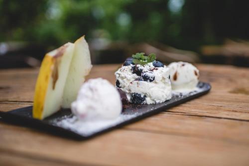 un piatto di formaggio e gelato su un tavolo di legno di Gemütliches Gästezimmer a Eickeloh