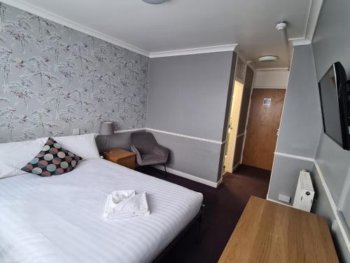 a hotel room with a bed and a table and a tv at Northumberland Hotel in Edinburgh