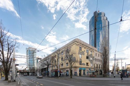 een stadsstraat met een gebouw en een hoge wolkenkrabber bij Cibona Station Apartments in Zagreb