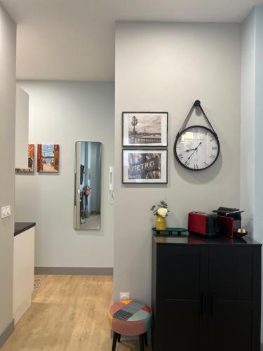 une chambre avec une horloge sur un mur blanc dans l'établissement D’AZUR-35, à Nice