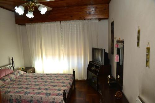 een slaapkamer met een bed en een televisie. bij Departamento en Jauregui (partido de Luján) in Luján