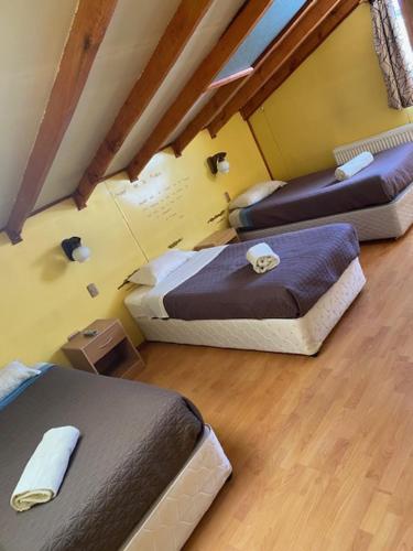 a room with three beds in a room at Nikos II Adventure in Puerto Natales