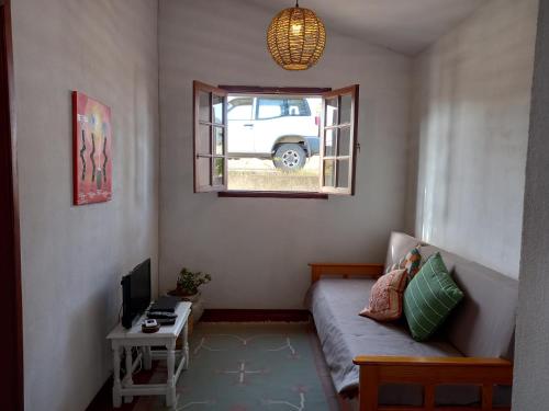 a small living room with a couch and a window at Quintinha das Lombas S in Porto Santo