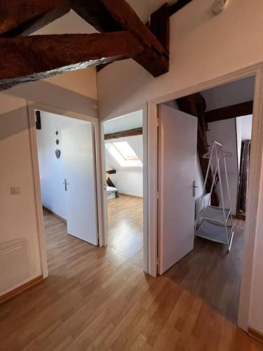 an empty room with two open doors and a treadmill at Gîte du Coudray in Neuillé-Pont-Pierre