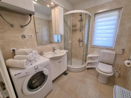 un bagno con lavatrice e lavandino di Villa Ilaria a Bol