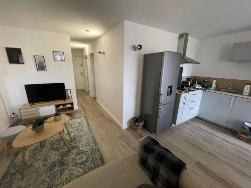ein Wohnzimmer mit einem Tisch und einer Küche in der Unterkunft Très bel appartement, port Sanary, in Sanary-sur-Mer