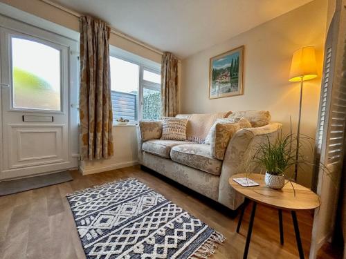 a living room with a couch and a table at BOURNECOAST: LOVELY GROUND FLOOR STUDIO APARTMENT, NEAR RIVER & BEACHES - FM3001 in Iford