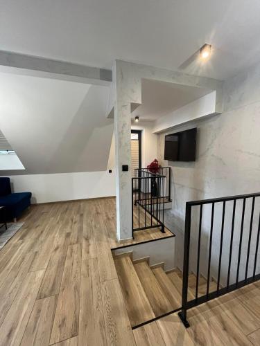 an empty living room with a staircase and a couch at Apartamenty na Blichu - Noclegi Energylandia Zator in Zator