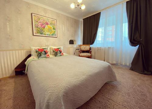 a bedroom with a large bed with flowers on it at Erdvus butas su balkonu šalia ežero ir stadiono in Visaginas