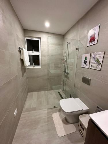 a bathroom with a toilet and a glass shower at LUXURY CONDO Cana Bay 1 CLUB BEACH in Punta Cana