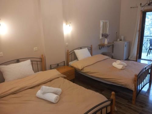 a room with two beds with towels on them at Φαράγγι Καρδαμύλης in Exochori