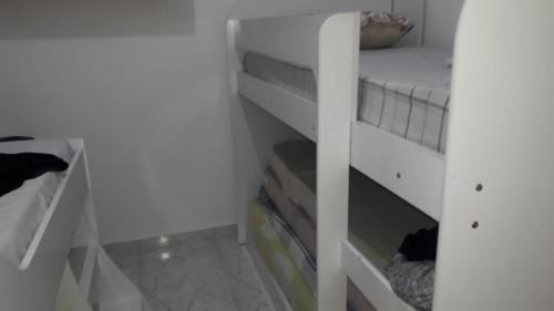 a room with a white bunk bed in a room at Casa das Gaivotas in Itanhaém