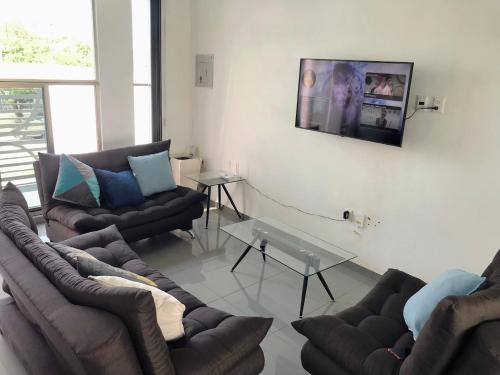 sala de estar con sofás y TV en la pared en Casa de Colima, en Colima