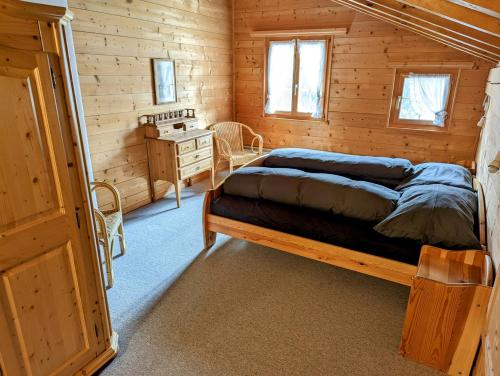 a bedroom with a bed in a wooden cabin at Maisonette-Wohnung in Rueras bei Sedrun in Rueras