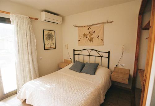 Sant Llorenç de la Muga的住宿－Hostal de l'Aigua，一间卧室配有一张带两个蓝色枕头的床