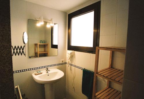 Sant Llorenç de la Muga的住宿－Hostal de l'Aigua，一间带水槽和镜子的浴室以及窗户。
