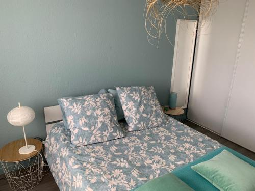 ein kleines Schlafzimmer mit einem Bett mit blauer Wand in der Unterkunft Chambre Le Crès in Le Crès