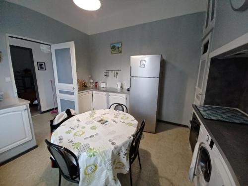 kuchnia ze stołem i białą lodówką w obiekcie maison 4 à 6 personnes proche village w mieście Pélissanne