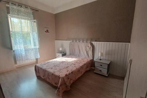 sypialnia z łóżkiem z narzutą i oknem w obiekcie maison 4 à 6 personnes proche village w mieście Pélissanne