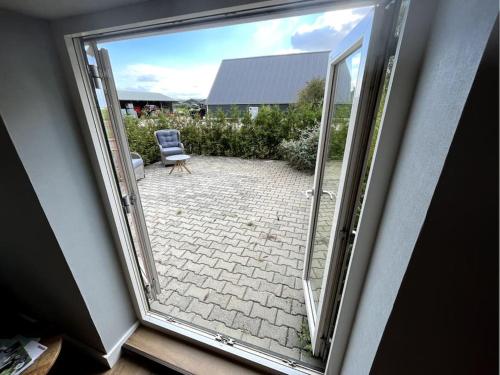 an open door to a patio with a chair outside at De Cordobahoeve in Tweede Exloërmond